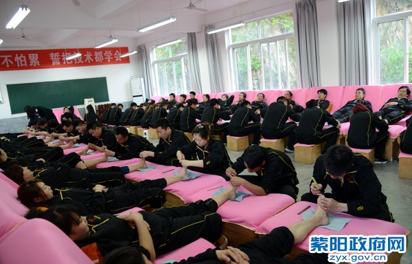 为加快贫困群众脱贫致富奔小康步伐，紫阳县立足县情实际，大力实施以修脚足疗为重点的订单定向免费技能培训，探索出了一条“政府主导+龙头企业+基地培训+定向就业”的技能脱贫路子，形成了党委政府造血脱贫、特色产业引领脱贫、市场主体带动脱贫、贫困群众自主脱贫的多元精准扶贫格局。截至目前，该县累计培训2万余人，带动1.4万余名贫困劳动力稳定就业。图为参训学员正在进行颈修脚技能培训练习。（陈刚  摄）.jpg